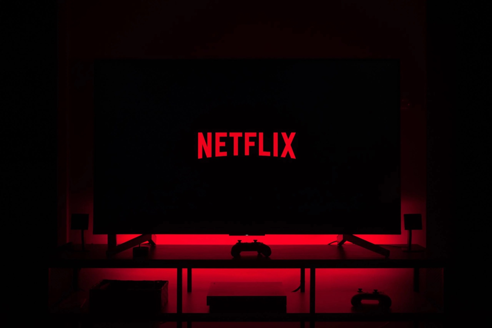A living room at night lit in red, with the Netflix logo on the TV